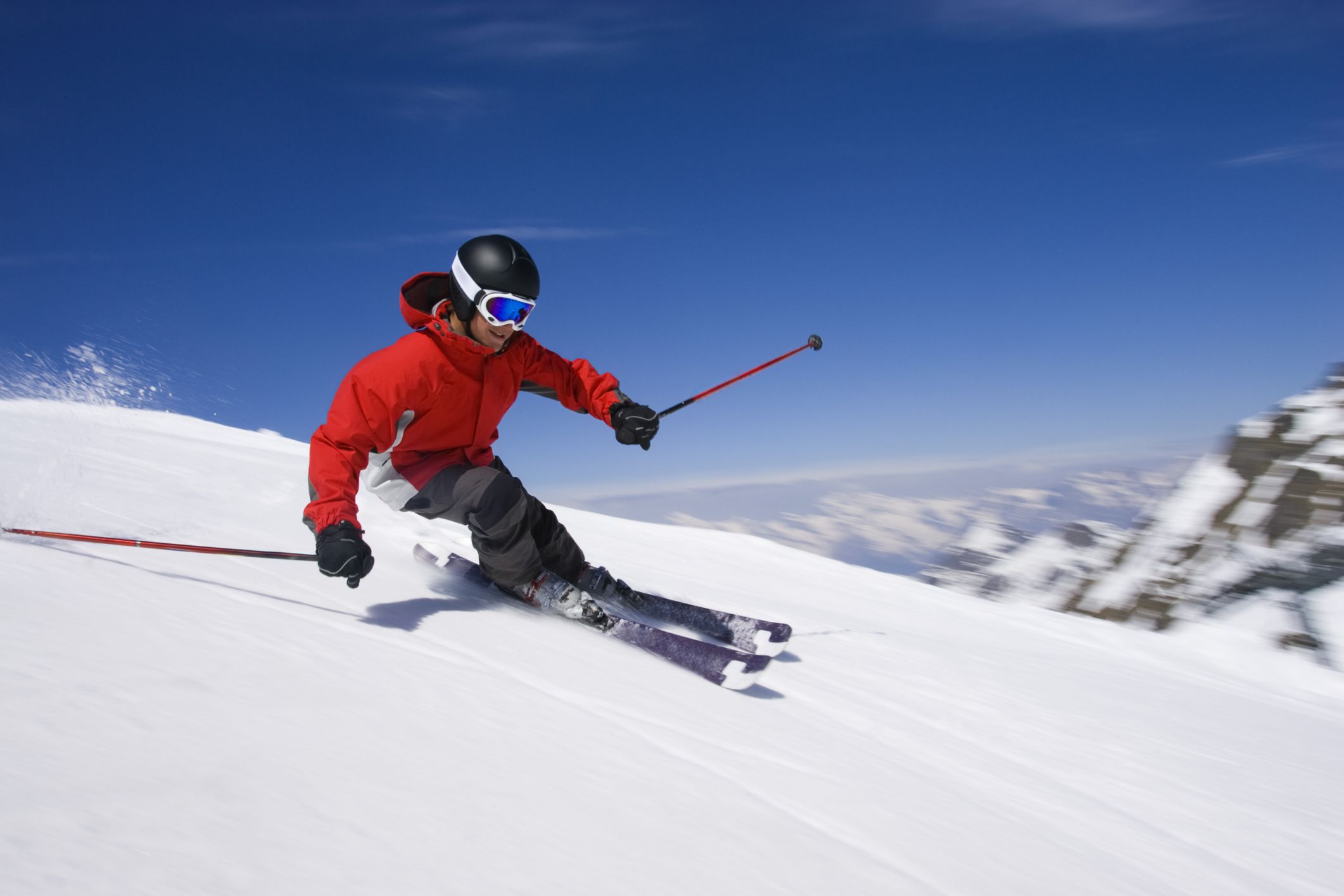 Лыжник скатывается. Горнолыжный спорт. Лыжник в горах. Катание на горных лыжах. Спуск с горы на лыжах.